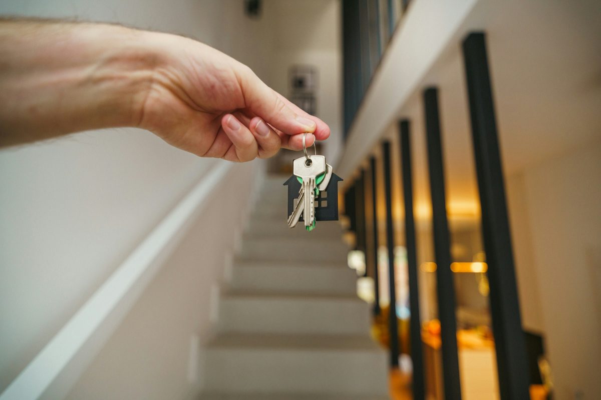 Hand holding the keys to a new home with a small house keyring
